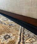 Adjustable Under Couch Gap Shield Blocking Toys Dust And Remotes From Snaking Under Sofas Beds Or Cabinets With Hassle Free Snap Fit And Tough Flexible Core beside beige couch and patterned rug.