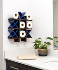 Tic Tac Toe Toilet Paper Holder Dope Wall Mounted Storage displaying toilet paper rolls and blue X's in modern bathroom decor