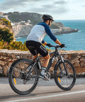 Cyclist riding Beast 1000W Peak Electric Mountain Bike for Adults along coastal road