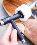 Person holding a skateboard tool next to a skateboard wheel with Reds Bearings 8 Pack for skateboards longboards scooters and spinners