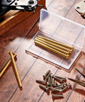 6 Pack Door Hinge Pins 3.5 Inch Legit Oil Rubbed Bronze And Gold Heavy Duty Stainless Steel displayed in clear case on wooden surface.