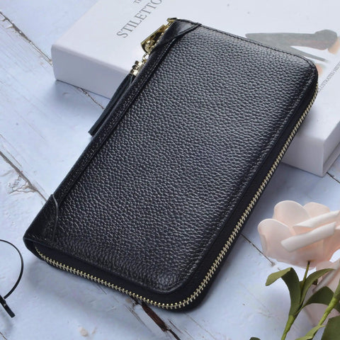 Women's RFID Blocking Leather Card Holder Wallet with Zipper Purse Case in black cowhide leather on a wooden surface.
