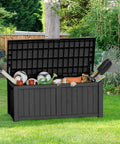 All Weather Outdoor Storage Box Bench, 150 Gallon Lockable And Waterproof Storage Chest filled with garden tools and accessories in Onyx Black on patio.