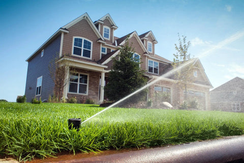 Tough As Nails Gear Drive Pop Up Lawn Sprinkler Boasting Preinstalled Number 6 Nozzle watering grass in residential lawn.