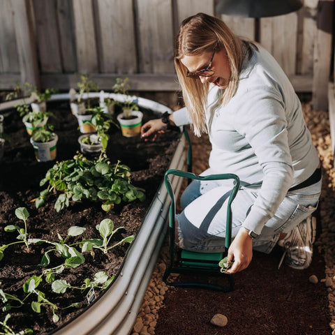 Woman using 2-In-1 Garden Kneeler And Seat With Cushioned Pad, Foldable Stool for Weeding And Planting near raised garden bed