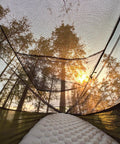 View from inside Bug Free Camping Hammock With Mosquito Net, sunset through breathable mesh shelter in forest, ultralight design
