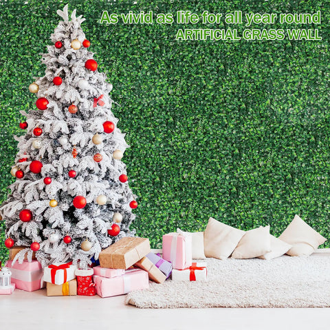 Snow-covered Christmas tree with presents in front of 24 Pack 20x20 Inches Artificial Boxwood Panels For Privacy Hedge Screen Outdoor Indoor Garden Fence Backyard Decor UV Protected Realistic Dense Leaves No See Through Privacy Solution wall.