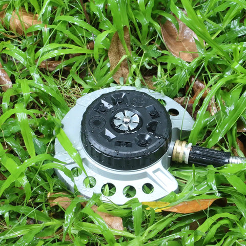 Nine Pattern Turret Lawn Sprinkler with heavy duty metal base, showing nine adjustable spray patterns on grass.
