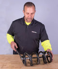 Man using Heavy Duty Coil Spring Compressor With Detent Locks And Built In Safety Gauge For Quick Auto Suspension Service on table