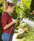 Woman using Stainless Steel Garden Hose With 10 Function Spray Nozzle, 100 Ft No Kink Metal Water Hose for outdoor watering