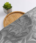Close-up of charcoal gray sheer curtain panel with leaf texture, showing light filtering jacquard drapes for bedroom or living room.