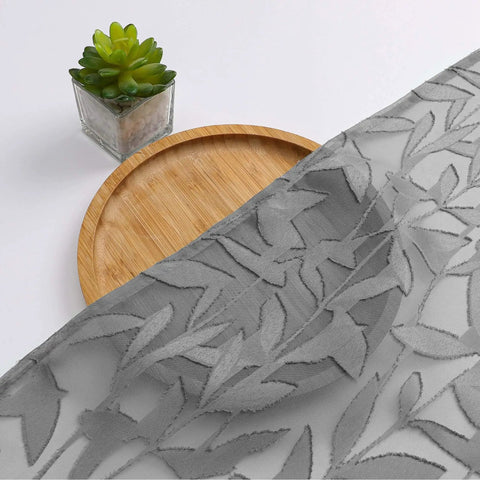 Close-up of charcoal gray sheer curtain panel with leaf texture, showing light filtering jacquard drapes for bedroom or living room.