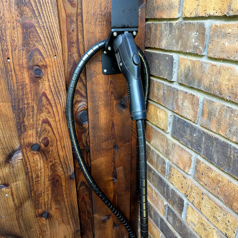 Tough As Nails EV Charger Cable Protector Featuring Flexible Wire Sleeve And Anti Wear Guard Designed For 7/8 Inch Cables mounted on wall.