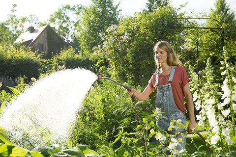 Woman using 29 Inch Sprayer Wand With Stainless Head For Easy Watering Of Hanging Baskets Plants Flowers Shrubs And Lawn UV protected
