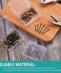 75 Piece Picture Hanging Nails Set In Three Sizes Small Medium Large With Brass Head And Black Steel Finish in boxes on table.