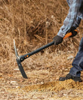 Person using IsoCore Dual Ended Pickaxe And Hoe With 36 Inch Shock Absorbing Handle for digging soil, showing orange and black tool in action.