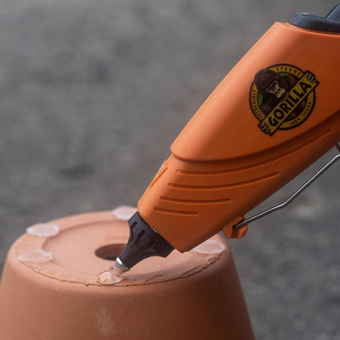 Glue gun applying bond using Clear Mini Hot Glue Sticks 4 Inch Long 0.27 Inch Diameter 75 Count on terracotta pot