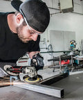 Heavy Duty 7 Inch Pneumatic Angle Grinder Packing 8500 Rpm used by a man cutting metal, with sparks flying in a workshop.