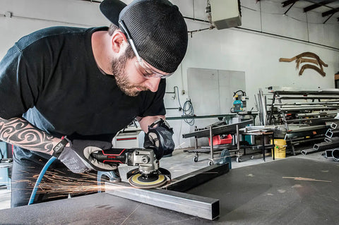 Heavy Duty 7 Inch Pneumatic Angle Grinder Packing 8500 Rpm used by a man cutting metal, with sparks flying in a workshop.