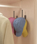 Heavy Duty Stainless Steel Hat Organizer And Hat Rack For Wall Built Tough To Store Your Favorite Baseball Caps Without Breaking A Sweat hanging three caps in a closet.