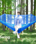Couple sitting in Ultra Comfy Camping Hammock With Mosquito Net, 13ft Tree Straps And Carabiners, blue outdoor setup