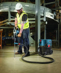 Worker using SDS Max Speed Clean Dust Extraction Bit for Vacuum Connected Drilling, enhancing anchor installations in industrial setting.