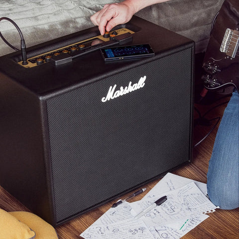Code50 Digital Guitar Amplifier With Fifty Watt Output One Hundred Plus Presets Twenty Four Digital Effects Fourteen Preamp Models Bluetooth Connectivity Three Point Five Millimeter Aux Input Versatile Tone For Practice Rehearsal And Live on a wooden floor with papers and a guitar nearby