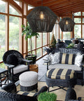 7 Inch Handwoven Rattan Pendant Light With Matte Black Basket Shade in modern boho seating area, featuring wicker chairs