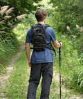 Rugged Tactical Hydration Pack With 2.5L Bladder, MOLLE System, Low Profile Backpack for hiking in a forest, rear view