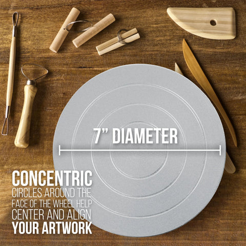 7-inch diameter metal sculpting wheel on wooden work surface with clay sculpting tools nearby