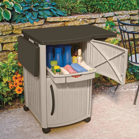 Outdoor Grilling Prep Station With Storage Portable Backyard Kitchen Counter Durable Resin Weather Resistant Top Cabinet For Serving Tray And More With Drop Leaf Extensions Taupe Brown, with cabinet open showing contents, set in garden area.