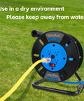 Heavy Duty Extension Cord Reel With Four Grounded Outlets And 10A Circuit Breaker on grass, caution text visible