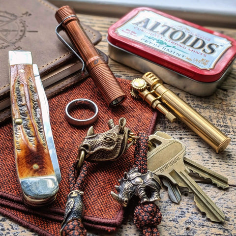 Pocket Size EDC Flashlight With Clip 92 Plus CRI Natural Light among everyday carry gear on wooden surface