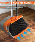 Upgraded Broom and Dustpan Set With a 52-Inch Long, Adjustable Handle for Standing Cleaning Self-Cleaning Teeth No Bending Great for Pet Hair and Everyday Messes in Kitchen Office Home Indoor and Outdoor Use Orange and Gray showing close-up of broom sweeping debris into dustpan on wooden floor.