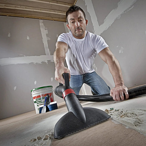 Man using vacuum to clean drywall dust with high efficiency disposable filter bags for 15-22 gallon tanks white 2-pack