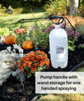 Two Gallon Lawn And Garden Sprayer With 34 Inch Anti Kink Hose placed in a garden bed with flowers and pumpkins.