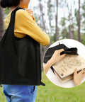 Person holding 11x11 Inch 10 Layer Flower Press Kit for Diy Crafts pressed flowers and plant pressing in black bag outdoors.