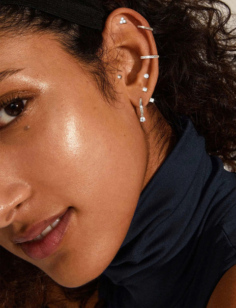 Lightweight Hypoallergenic Silver Earring Stacks For Women 7 Pair Set Lets You Mix And Match CZ Studs Ear Jackets Ball Studs Butterflies Hoops And More In Stainless Steel For Sensitive Ears on model with silver hoops and studs