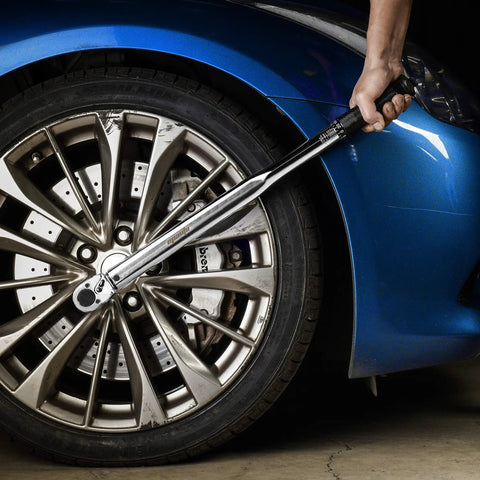 Half Inch Drive Click Torque Wrench 25-250 Ft-Lb Range being used on a car wheel, shows Cr-V ratchet head and non-slip knurled grip.