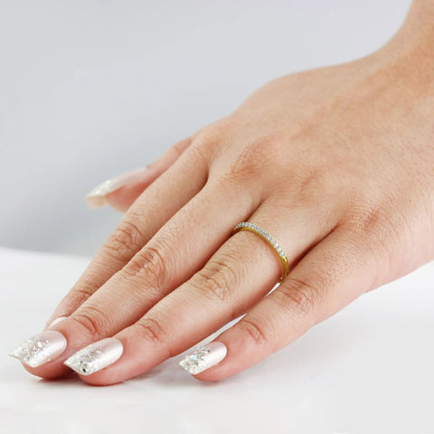 Real Deal 0.15 Ctw Genuine Round Cut Diamond Wedding Band Encased In Solid 14K Yellow Gold Machine Set worn on hand with manicured nails.
