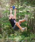Child enjoying Zip Line Kit 150 Feet With Seat And Carabiner Heavy Duty One Quarter Inch Galvanized Cable Backyard Fun For Families Supports Up To 350 Lbs Weather Resistant Easy Setup For Hours Of Outdoor Adventure in forest.