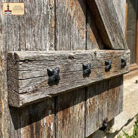 Close-up of Colonial Era Solid Cast Iron Decorative Nailhead Studs For Doors, Cabinets And Furniture in rustic setting