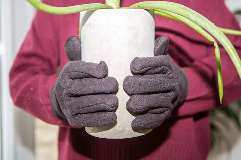 Brown Jersey Winter Work Gloves With Red Fleece Lining for all day comfort and warmth holding a potted plant