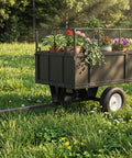 Beefy Heavy Duty Steel Dump Trailer Cart With 750 Lb Capacity 17 Cu Ft Tow Behind Utility Trailer Removable Mesh Sides And Pneumatic Tires For ATV UTV Lawn Tractor Yard And Farm Hauling Black in a grassy field with potted plants