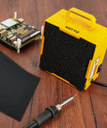 Dual Activated Carbon Filter Solder Fume Extractor With Slick Removable Magnetic Flaps And Steady Airflow on wooden surface.