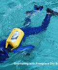 Person snorkeling with yellow 5L Waterproof Dry Bag Set Of 3 With Double Zip Locks Includes Waist Pouch And IPX8 Phone Case