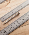 Top view of Beefy Machinist Ruler Set Four Pack Stainless Steel With Six Eight Twelve And Fourteen Inch Lengths around a screw on wood surface