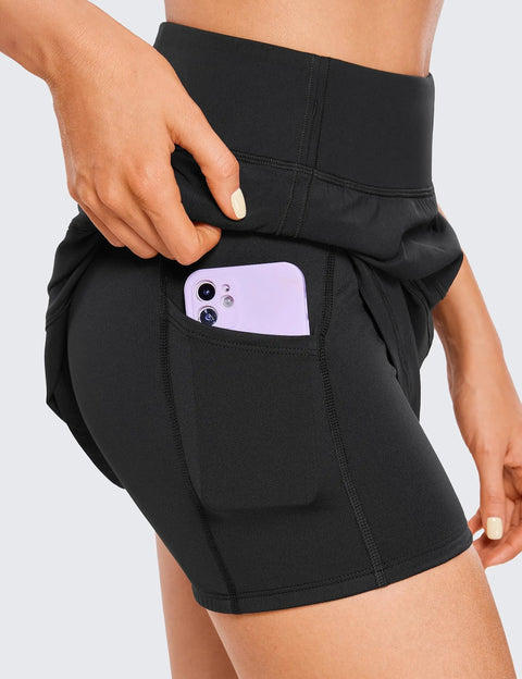 Close-up of black High Waisted A Line Golf Skirt With Built In Short Ultra Soft Quick Dry Fabric featuring pocket with phone.