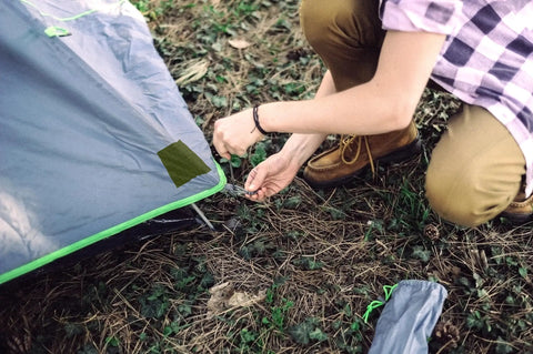 Person applying Nylon Repair Tape For Tents And Gear Durable Waterproof Flexible Patches For Fabric Repairs Fast Fix No Glue Or Heat to tent.