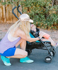 Woman kneeling next to baby in stroller holding insulated leak proof straw lid for Summit and Hydro Flask wide mouth bottles road trip ready